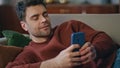 Chilling man messaging cellphone lying on apartment couch close up. Smiling guy Royalty Free Stock Photo