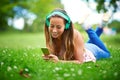 Chilling at the park with her favorite songs. a young woman listening to music while lying on the grass at the park. Royalty Free Stock Photo