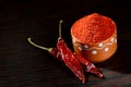 Chilly powder in clay pot with red chilly, dried chillies on wooden background Royalty Free Stock Photo