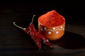 Chilly powder in clay pot with red chilly, dried chillies on wooden background Royalty Free Stock Photo