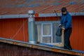 CHILOE, CHILE - SEPTEMBER, 27, 2018: Unidentified man cleanning his house on stilts palafitos in Castro, Chiloe Island Royalty Free Stock Photo