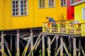 CHILOE, CHILE - SEPTEMBER, 27, 2018: Unidentified man in his yellow house on stilts palafitos in Castro, Chiloe Island Royalty Free Stock Photo