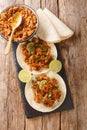 Chilorio is a pork dish from the Mexican state of Sinaloa served with tortilla and lime closeup in the slate board. Vertical top