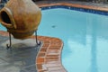 Chimenea next to the pool full of clear water on the rainy weather day on blurred background