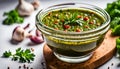 Chimichurri verde in a glass bowl on a white background