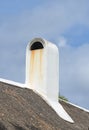 Chimney designed on the roof of a house or building outside against a cloudy sky background with copyspace. Old, dirty
