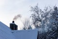 Chimney with grey smoke at cold winter day.