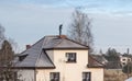 A chimney sweep cleans the chimney on the roof of a detached house