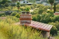 Chimney on top of adobe house with flat red roof tiles in the hills of arizona wilderness in the sonora desert landscapes Royalty Free Stock Photo