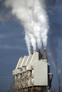 Chimneys spew pollution into the blue sky