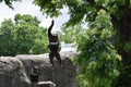 Chimpanzee in mid jump for a branch on a tree