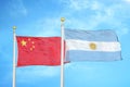 China and Argentina two flags on flagpoles and blue cloudy sky Royalty Free Stock Photo