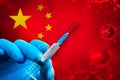 China Covid-19 Vaccination Campaign. Hand in a blue rubber glove holds a syringe with covid-19 virus vaccine in front of China Royalty Free Stock Photo