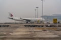 China Eastern Airbus A330 is parked on apron and a lonely person in protective suit