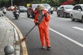 City street cleaners in special clothes with panicles and straw hats 