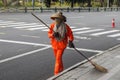City street cleaners in special clothes with panicles and straw hats