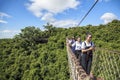 China, Hainan Island - December 1, 2018:Tourists are walking on a wooden suspension bridge in the park of Yalong Bay Tropic Royalty Free Stock Photo