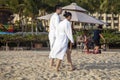 China, Hainan Island - Yalong Bay, the best beach in Hainan Island, young Chinese couple in white coats walking