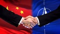 China and NATO handshake, international friendship relations, flag background