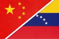 China or PRC vs Venezuela national flag from textile. Relationship between asian and american countries