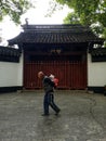 China Street scene, grandfather carrying young child in front of ancient Confucius temple.