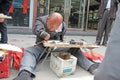 China, Suzhou - April 14, 2012. A man with a disabled person writes calligraphy, Chinese characters on the fan, sneers for Royalty Free Stock Photo