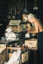 China town Bangkok Thailand December 2018 old Chinese man in herbal shop or Chinese herb store dried wooden antique cupboard and Royalty Free Stock Photo