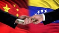 China and Venezuela officials exchanging money, flag background, cooperation