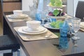 Chinaware setting on dining table with light blue crystal glass