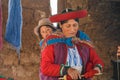 CHINCHERO, PERU- JUNE 3, 2013: Native Cusquena woman dressed in traditional colorful clothing explaining the dyeing threads and we