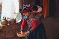 CHINCHERO, PERU- JUNE 3, 2013: Native Cusquena woman dressed in traditional colorful clothing explaining the dyeing threads and we