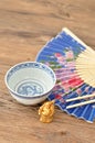 Chines bowl, chopsticks, a blue hand fan and a smiling Buddha Royalty Free Stock Photo