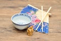 Chines bowl, chopsticks, a blue hand fan and a Buddha Royalty Free Stock Photo