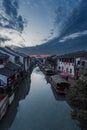 Chinese ancient town with red paper lanterns, reflecting off the shimmering water and the buildings