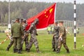 Chinese army soldier in a chemical protection suit against the background of the flag of the people`s army of China