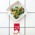 Chinese beaten cucumbers salad, top view, white background, place for text. Cute funny happy Maneki neko show number on
