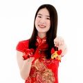 Chinese beautiful woman smiling in red dress is showing a red doll on her right hand and a yellow doll on her left hand to a