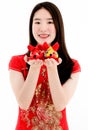 Chinese beautiful woman smiling in red dress is showing a red doll on her right hand and a yellow doll on her left hand to a