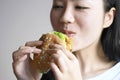 Chinese beauty girl eat hamburger, blank white background Royalty Free Stock Photo