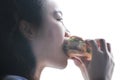 Chinese beauty girl eat hamburger, side face closeup Royalty Free Stock Photo