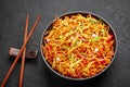 Chinese Bhel in black bowl on dark slate table top. Indo-Chinese cuisine street food dish with schezwan sauce