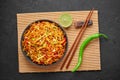 Chinese Bhel in black bowl on dark slate table top. Indo-Chinese cuisine street food dish with schezwan sauce