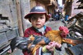 Chinese boy farmer is holding rooster bright, multi-color painting.