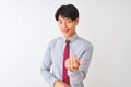 Chinese businessman wearing elegant tie standing over isolated white background Beckoning come here gesture with hand inviting
