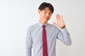 Chinese businessman wearing elegant tie standing over isolated white background Waiving saying hello happy and smiling, friendly Royalty Free Stock Photo