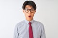 Chinese businessman wearing tie and glasses standing over isolated white background scared in shock with a surprise face, afraid Royalty Free Stock Photo