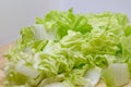 Chinese cabbage is cut into pieces and placed on a wooden cutting board on white background, Slicing vegetables prepared for