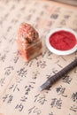 Chinese calligraphy and a seal and ink pad and a carving knife Royalty Free Stock Photo
