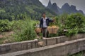 Chinese carrying pole over shoulder with baskets of oranges hang Royalty Free Stock Photo