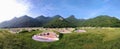 Chinese cemetery on the mound in the meadow next to the mountains.